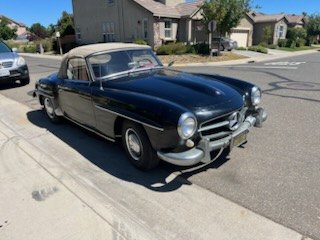 Dark blue European classic coupe parked on a suburban street