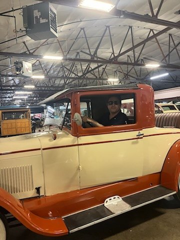 Orange and cream 1930s pickup truck inside a workshop