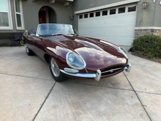 Maroon Jaguar E-Type coupe in a residential driveway