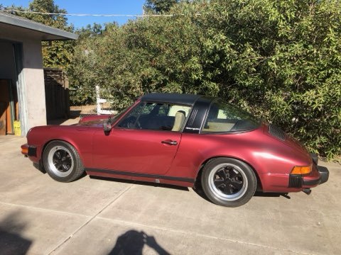 Red Porsche 911 Targa parked outside a house