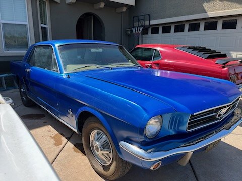 Blue 1960s Ford Mustang parked in a driveway
