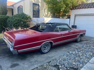 Red 1960s Chevrolet convertible parked in a driveway