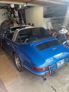 Blue Porsche 911 inside a crowded home garage