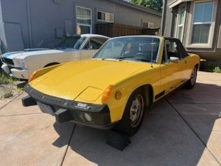 Yellow Porsche 914 project car on jack stands