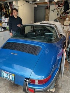 Blue Porsche 911 Targa in a garage with the owner standing beside it