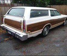 White wood-panel station wagon parked at night