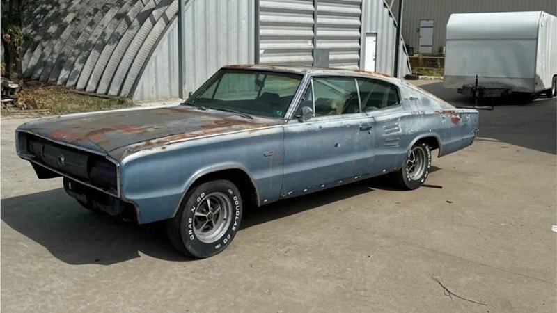 Blue Dodge Charger fastback parked outside a garage
